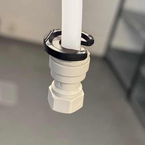 DmFit åpningsverktøy 3/8" i svart plast rundt hvit slange og push-fit kobling.