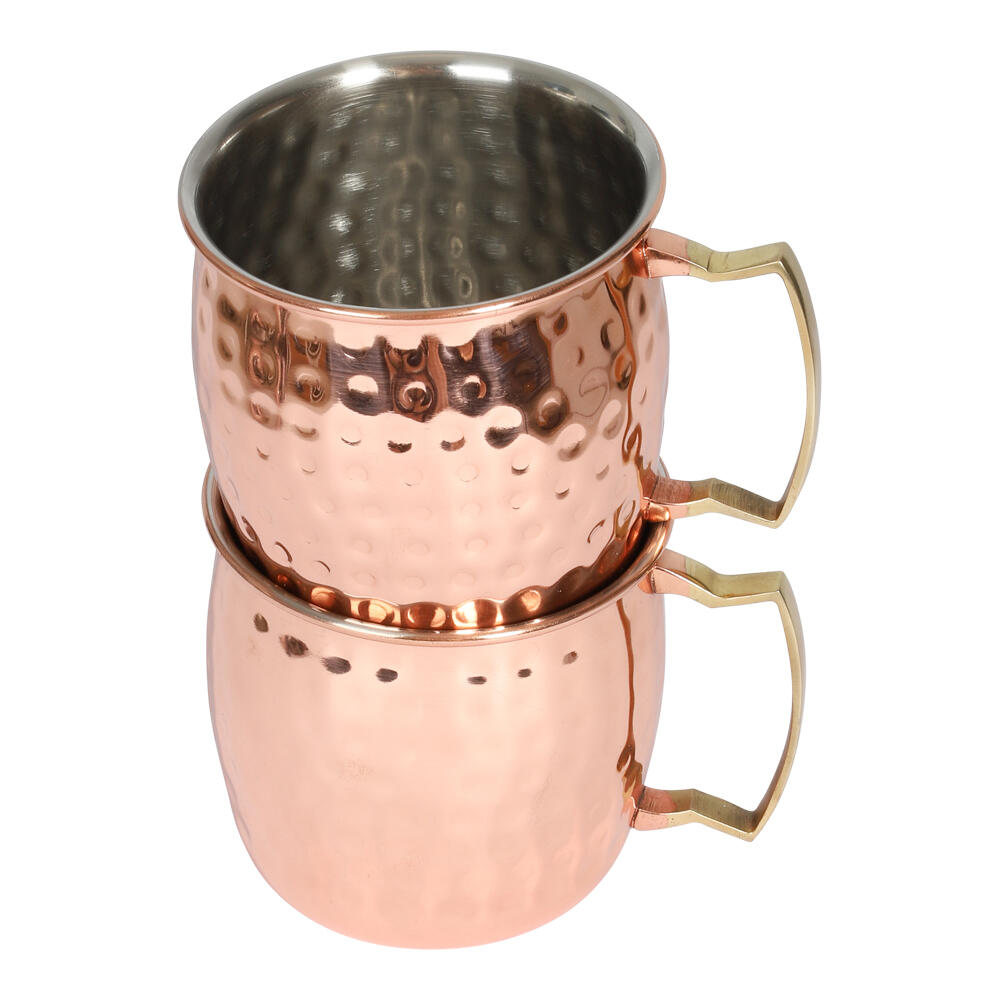 To kobberbelagte Moscow Mule krus med hamret tekstur og messinghåndtak, stablet.