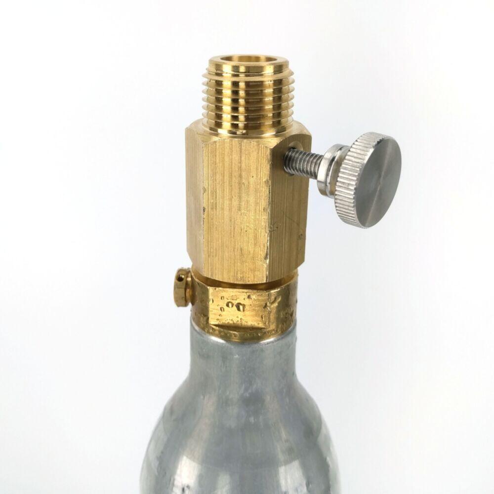 Gullfarget Sodastream adapter med justeringspinne på en sølv CO2-flaske.