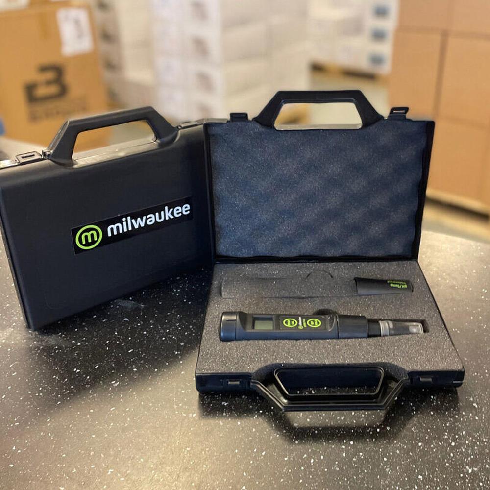 Svart Milwaukee bærekoffert for pH-målere, med åpen og lukket koffert, skuminteriør og en digital pH-måler.