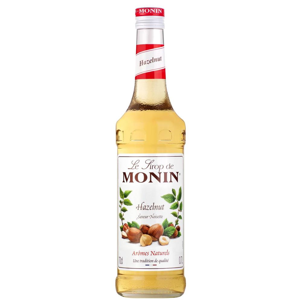 Monin Hasselnøtt sirup 70 cl i glassflaske med rød og hvit etikett, perfekt til kaffe og dessert.