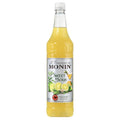 Monin Sweet & Sour Mix 1L flaske med gul væske og etikett som viser lime og sitron.