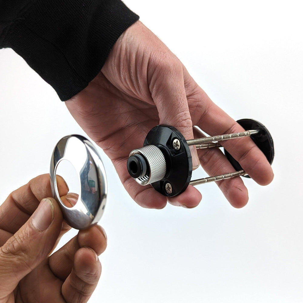 Hånd holder Nukatap Mini 6,35mm veggmontert shank-sett med krom finish og svart hurtigkobling.