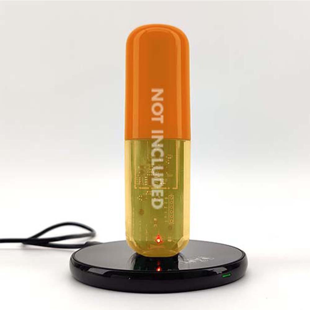 RAPT Pill trådløs lader med svart ladebrett og oransje pille, "NOT INCLUDED" tekst.