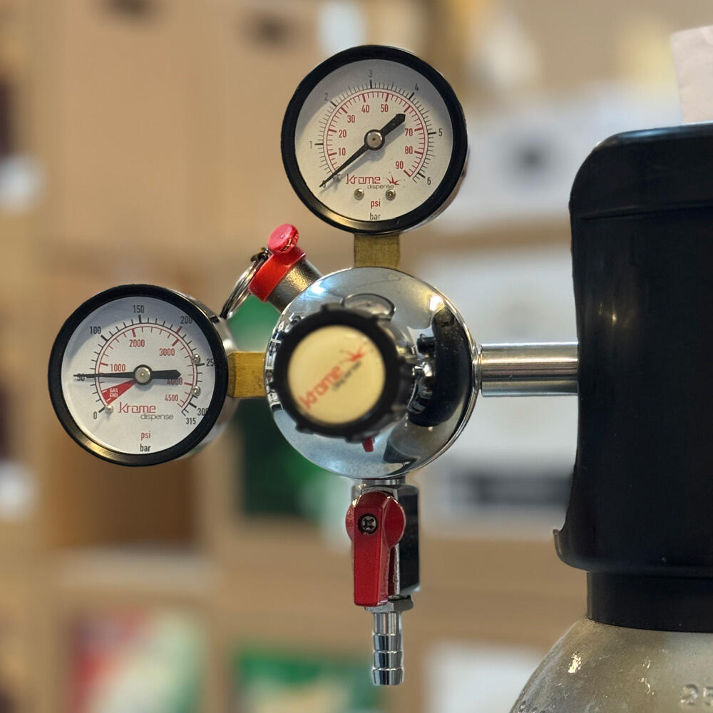 Krommet CO2-regulator med to trykkmålere, justeringsknapp og 5/16" slangestuss.