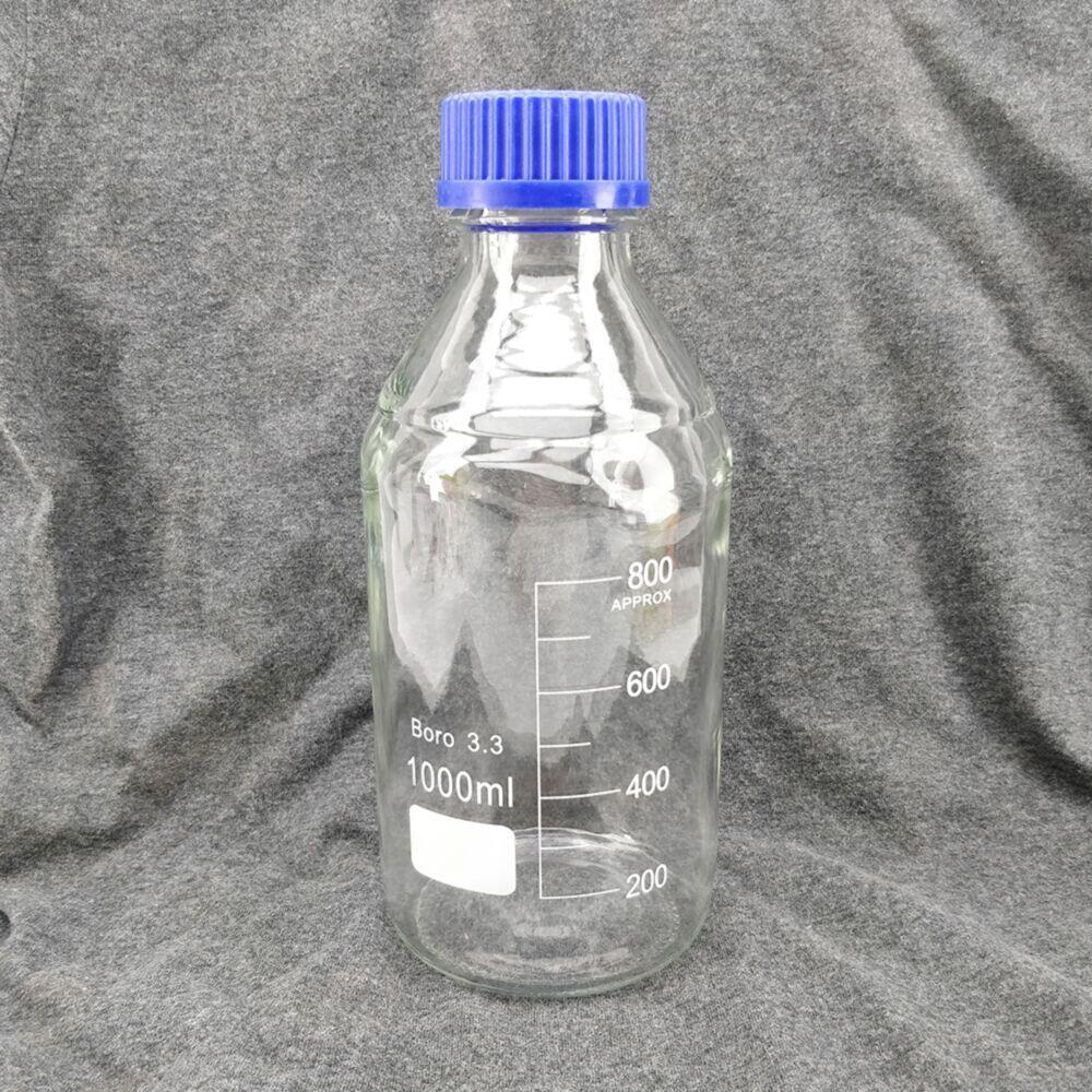 Klar 1000 ml borosilikatglass reagensflaske med blå skrukork og målemarkeringer.