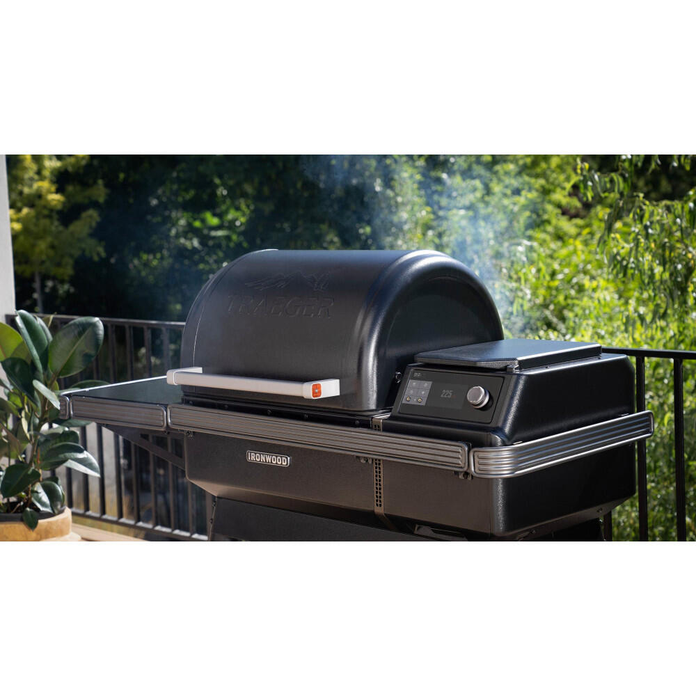 Traeger Ironwood XL pelletsgrill i svart med induksjonstopp og røyk som stiger opp.