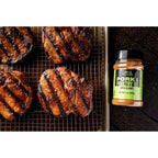 Traeger Pork & Poultry Rub 200g eple og honning, ved siden av grillet svinekjøtt på rist.