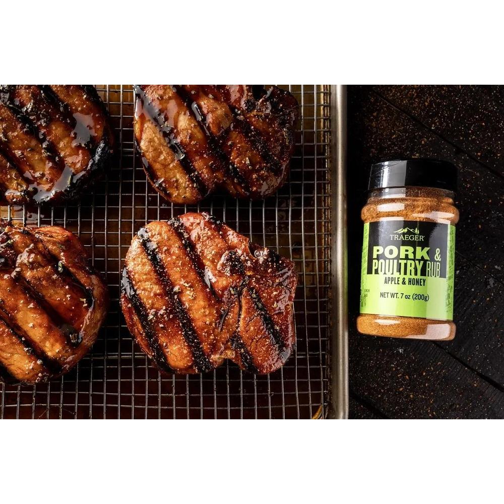 Traeger Pork & Poultry Rub 200g eple og honning, ved siden av grillet svinekjøtt på rist.