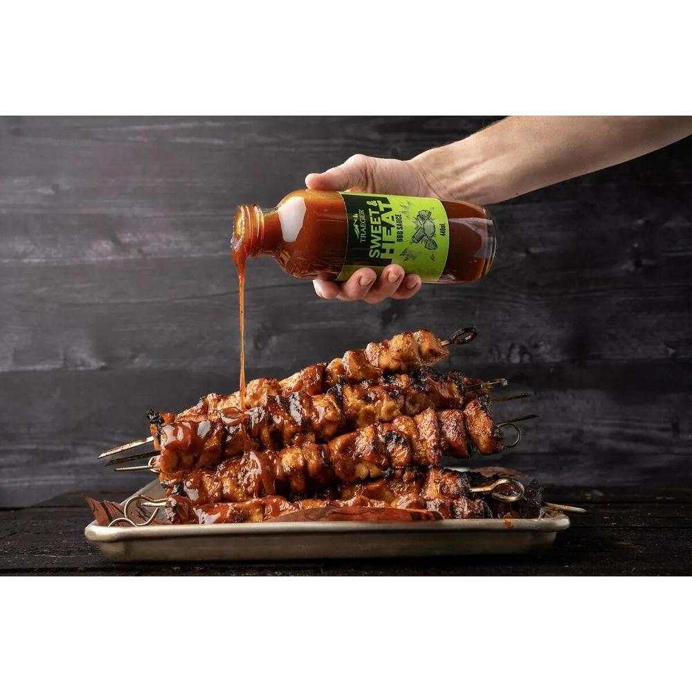 Traeger Sweet & Heat BBQ-saus helles over grillede kyllingspyd.