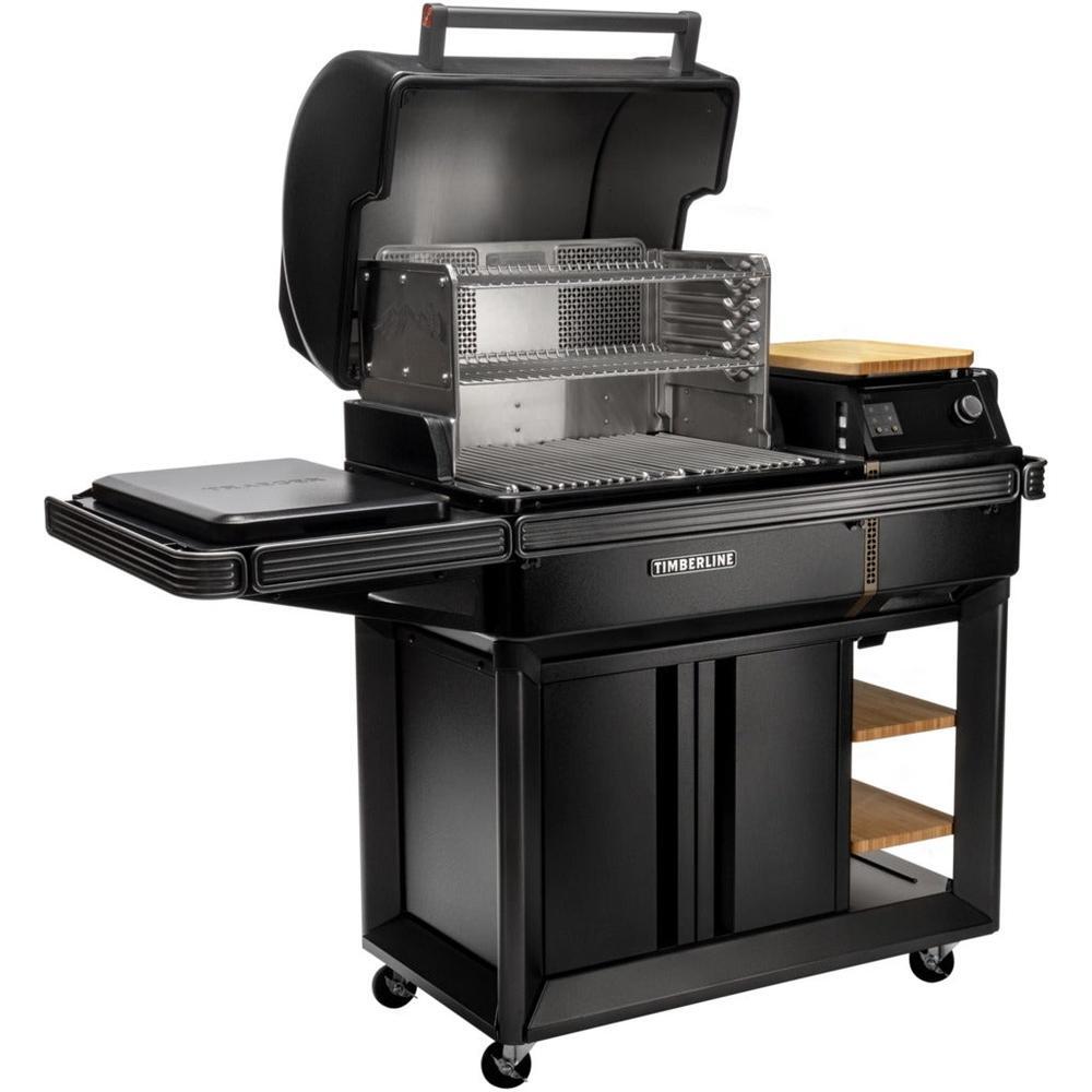 Traeger Timberline L pelletsgrill i matt svart med åpent lokk, sidebord, induksjonsplate og skap.